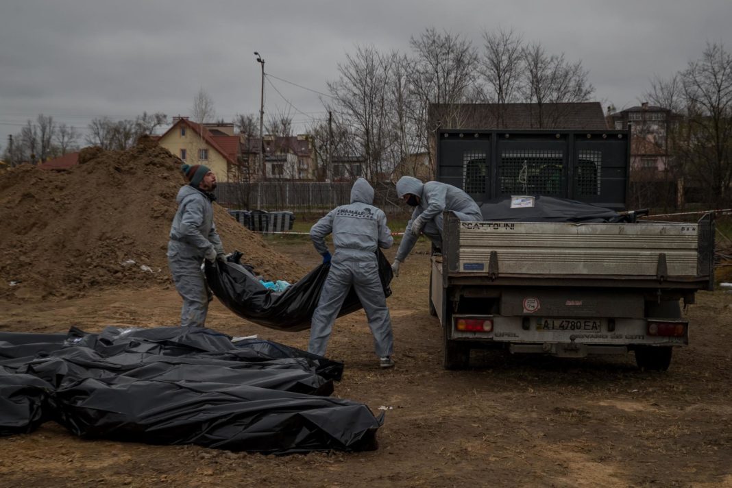 Fotografía de archivo en la que se registró a autoridades forenses la recoger cadáveres envueltos en plásticos para su traslado a la morgue, en Bucha (Ucrania). EFE/Miguel Gutiérrez

