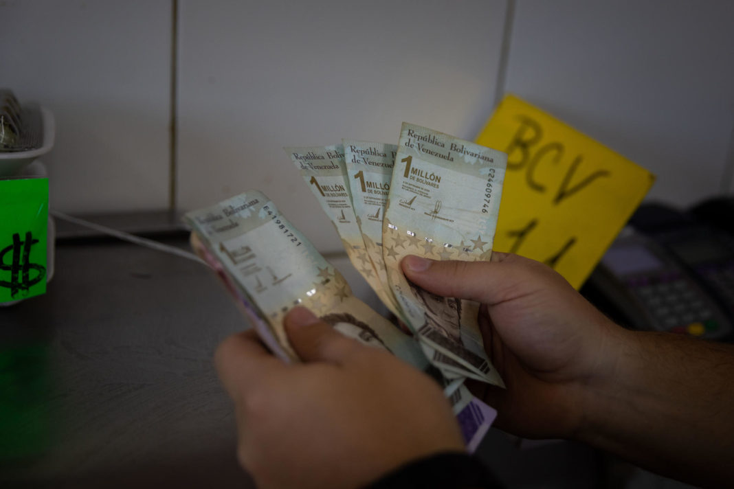 Un vendedor cuenta billetes de un millón de bolívares, en Caracas (Venezuela), en una fotografía de archivo. EFE/ Rayner Peña R.
