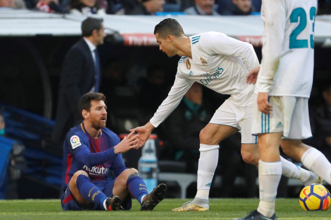 El delantero portugués del Real Madrid, Cristiano Ronaldo ayuda a levantarse al delantero argentino del FC Barcelona, Lionel Messi, durante un Clásico de LaLiga. EFE/Juan Carlos Hidalgo
